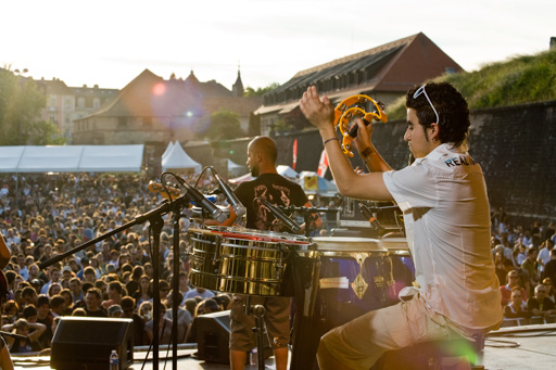 Mise en valeur de la prestation du groupe de musique en montrant la taille de la foule assistant au spectacle.
