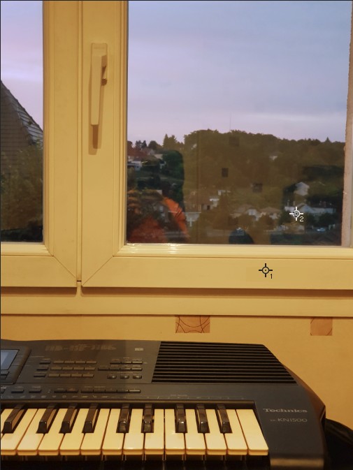 Photo prise en intérieur avec un réglage manuel de la balance des blancs pour neutraliser la dominante de couleur d'une façade d'une maison blanche