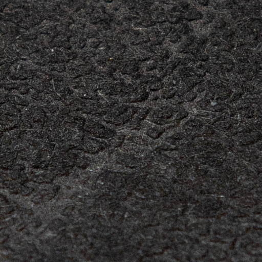 Texture d'une feuille de papier texturée noire en lumière directe et rasante