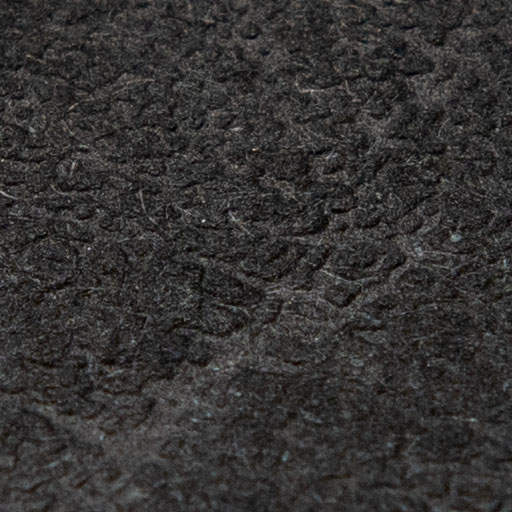 Texture d'une feuille de papier texturée noire en lumière directe